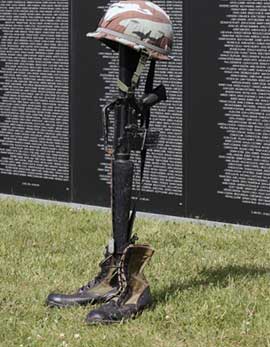 Rifle stuck in ground with helmet on top